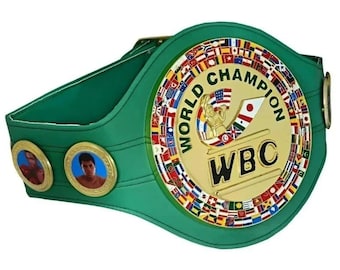 May include: A green World Boxing Council (WBC) championship belt with a gold center. The center features the words "WORLD CHAMPION" and "WBC" with a boxer figure. The belt has two circular medallions with boxer portraits.