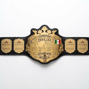 Könnte beinhalten: Ein schwarzer Leder-Meisterschaftsgürtel mit einer großen goldfarbenen Mittelplatte, die den Text CAMPEON DE PAREJAS AAA LUCHA LIBRE MEXICO und eine kleine mexikanische Flagge zeigt. Vier kleinere goldene Seitenplatten zeigen das AAA-Logo.