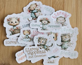 May include: A collection of die-cut stickers featuring adorable cartoon kittens. The stickers showcase kittens with floral accents, some with the words "Eternal Happiness" and "2026 Convention". The stickers are in various poses and designs.
