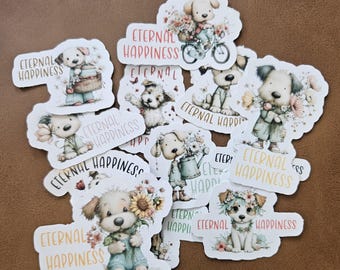 May include: A collection of die-cut stickers featuring adorable cartoon puppies with floral accents. Each sticker has the words "Eternal Happiness" in a decorative font. The puppies are depicted in various poses, some holding flowers or riding bicycles.