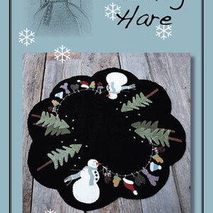 May include: A black felt Christmas tree ornament with a snowman and pine trees around the edge. The ornament is decorated with a string of colorful beads and the text "#39 Dress me up Frosty".