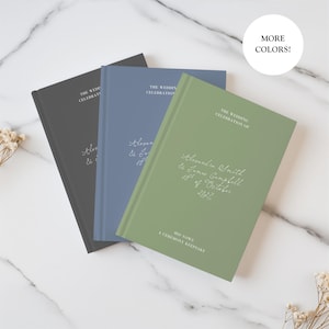 May include: Three hardback books in charcoal grey, dusty blue, and sage green. Each cover features white text reading THE WEDDING CELEBRATION OF, followed by custom names and dates in script, and HIS VOWS A CEREMONY KEEPSAKE at the bottom.