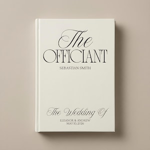 Può includere: Un libro color crema con testo nero. La copertina recita "The Officiant" sopra "Sebastian Smith" e "The Wedding Of" con i nomi "Eleanor & Andrew" e la data "May 10, 2026".