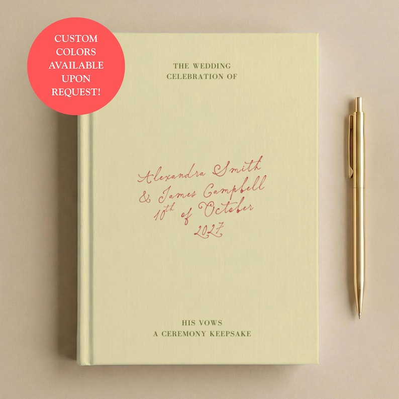 May include: A pale yellow hardback book with the text THE WEDDING CELEBRATION OF, Alexandra Smith & James Campbell 10th of October 2027, HIS VOWS, A CEREMONY KEEPSAKE printed on the cover. A gold-coloured metal pen is positioned to the right of the book.