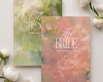 May include: Two hardcover books with abstract painted covers. The green book is titled The Groom His Wedding Vows, and the pink book is titled The Bride Her Wedding Vows. Both feature the names Eleanor & Andrew and the date June 10, 2027.