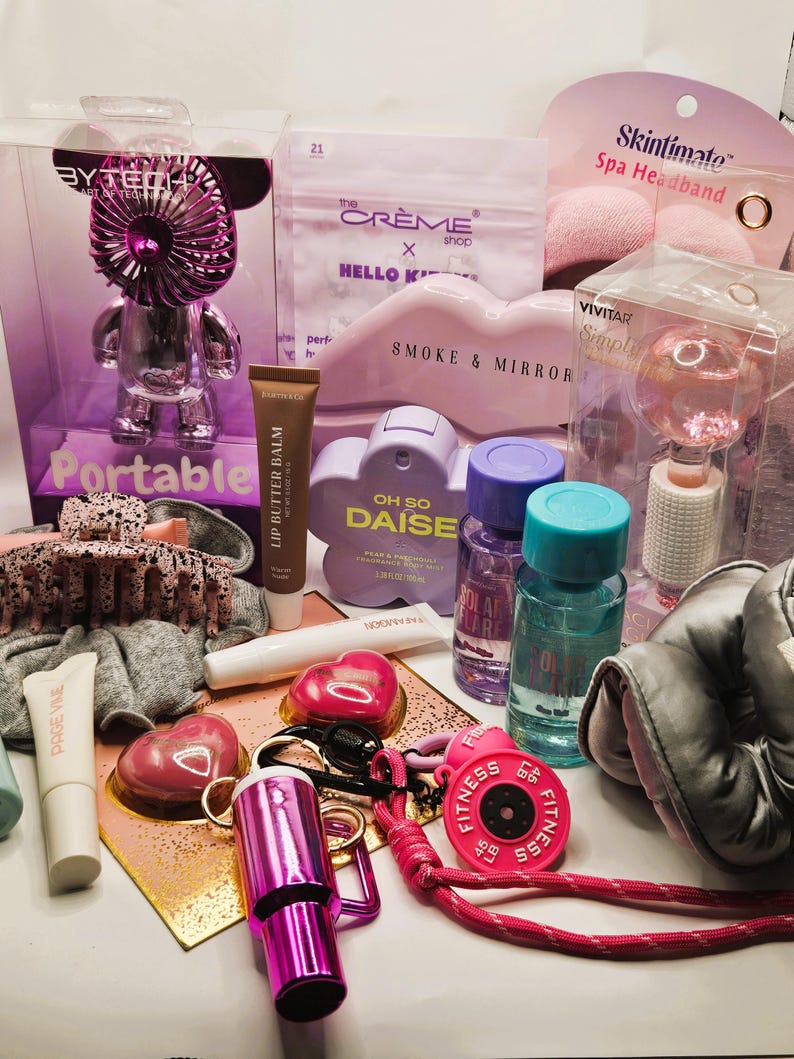 May include: A collection of beauty and lifestyle items including a Bytech portable fan, The Cr&egrave;me Shop Hello Kitty sheet mask, Skintimate spa headband, Vivitar facial globe, Oh So Daise fragrance, lip butter balm, hair claw, and a pink fitness weight keychain.