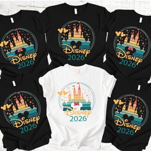 May include: Several black and white t-shirts with a colourful graphic. The design features a castle, Mickey Mouse ears, and the text "Disney 2026" within a circular frame. These shirts are likely themed for a Disney holiday.