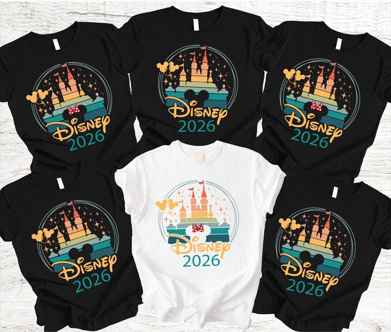 May include: Several black and white t-shirts with a colourful graphic. The design features a castle, Mickey Mouse ears, and the text "Disney 2026" within a circular frame. These shirts are likely themed for a Disney holiday.