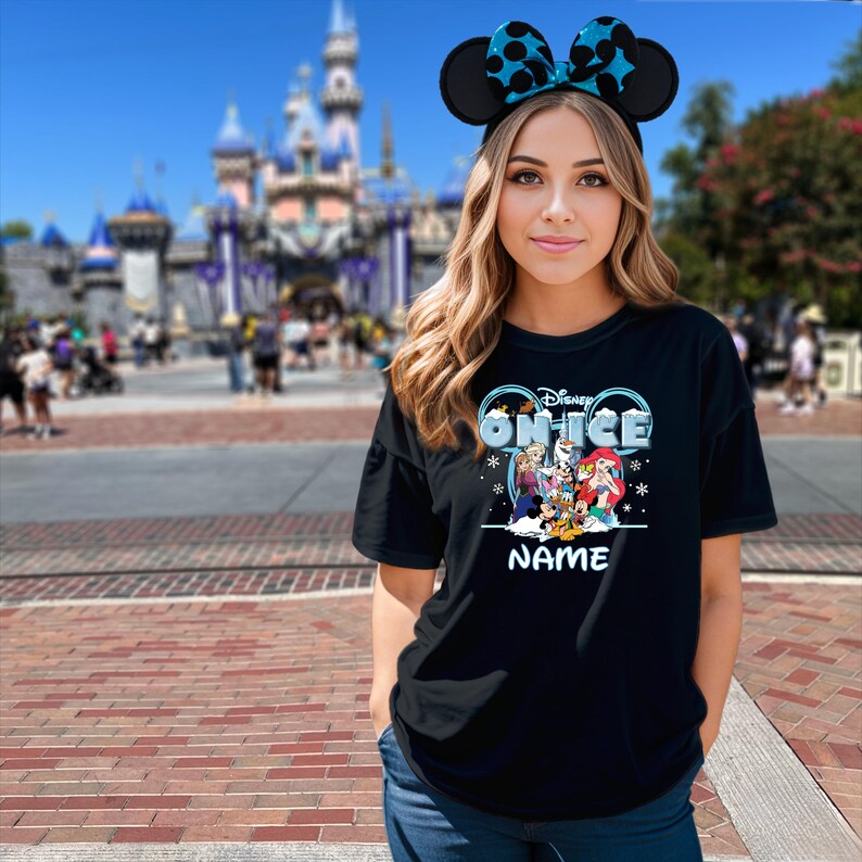 A young woman wearing a Disney-themed t-shirt and Mickey Mouse ears stands in front of a Disney castle.