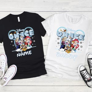 two t-shirts with Disney characters and the text "Disney ON ICE" printed on them, along with a pair of sneakers and a pair of black and white sneakers.