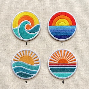 May include: Four round embroidered patches with sunset and ocean wave designs. Each patch features a white border. The first patch shows a yellow sun and a turquoise wave. The second patch has a rainbow sunset over blue water. The third patch has a yellow sun over turquoise waves. The fourth patch has an orange sunset over blue and turquoise water.