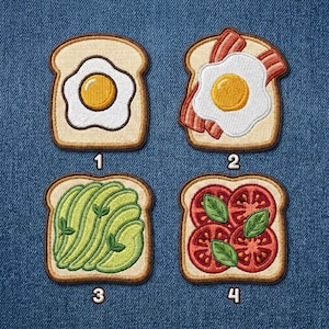 May include: Four embroidered patches shaped like slices of toast with various toppings. Patch 1 features a fried egg. Patch 2 shows a fried egg with bacon. Patch 3 displays sliced avocado. Patch 4 depicts tomato slices with basil leaves. Each patch is numbered.