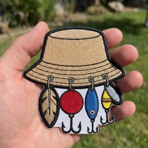 bucket hat with fishing lures AWatermansLife Waterman Polo Button Fishing Lure Stuck Hat Band