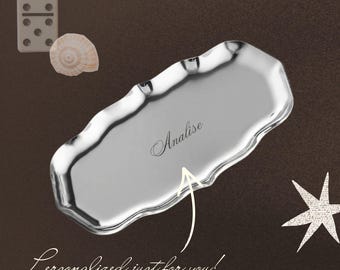 Op de afbeelding: Een zilverkleurig, langwerpig metalen dienblad met een geschulpte rand en een gepolijste afwerking. In het midden van het dienblad staat de naam Analise gegraveerd in cursief schrift. Een pijl wijst naar de naam met de tekst Personalized just for you!