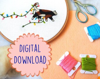 Puede incluir: Un patrón de descarga digital para un proyecto de bordado que presenta un gato con una cadena de luces coloridas envueltas a su alrededor. La imagen también muestra hilo de bordar, un aro y tijeras de bordar.