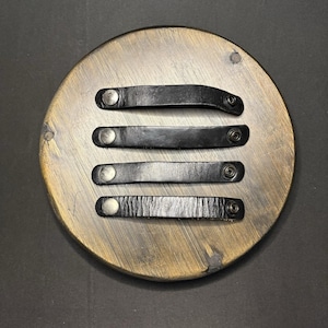 May include: Four black leather drawer pulls arranged horizontally. Each pull is a rectangular strip of leather with a silver-toned metal snap fastener at both ends, designed for attachment to furniture surfaces as a handle or pull.