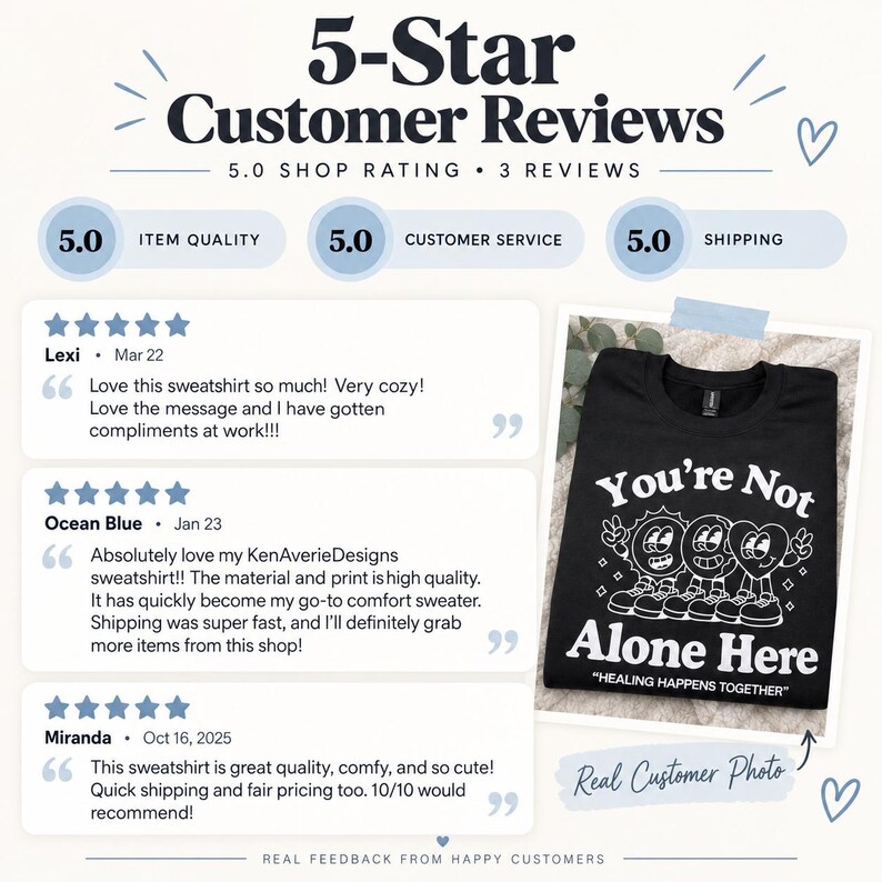 May include: A black sweatshirt featuring a white graphic print of a sun, a globe, and a heart character with the text You're Not Alone Here and HEALING HAPPENS TOGETHER, displayed alongside three five-star customer reviews and a shop rating.