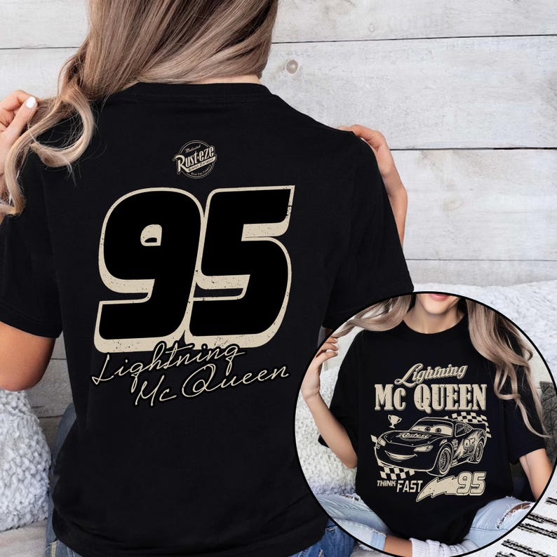 K&ouml;nnte beinhalten: Schwarzes T-Shirt mit der Nummer 95 in verblichener Schrift und dem Schriftzug "Lightning McQueen" darunter. Das Shirt hat auch eine kleine Grafik eines Rennwagens mit dem Text "Think Fast".
