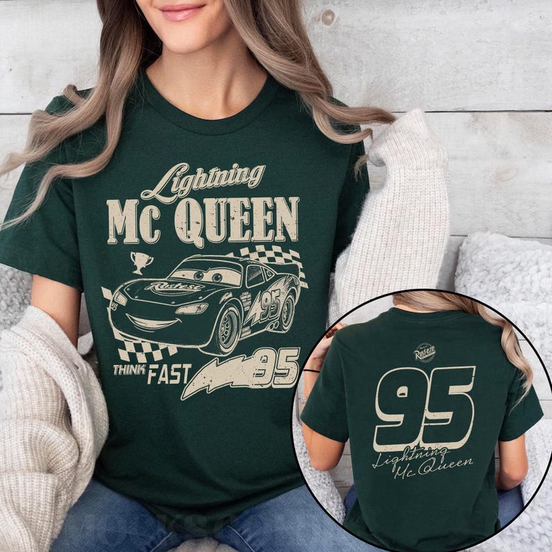 K&ouml;nnte beinhalten: Dunkelgr&uuml;nes T-Shirt mit Lightning McQueen aus dem Film Cars. Das Frontdesign zeigt den Text "Lightning McQUEEN", ein Cartoon-Auto und die Nummer "95". Auf der R&uuml;ckseite des Shirts sind die Nummer "95" und "Lightning Mc Queen" abgebildet.
