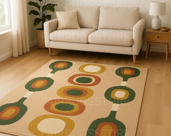 May include: Beige area rug with a retro design featuring large, colorful circles in green, orange, yellow, and white. The rug is placed on a hardwood floor in a living room setting, with a beige sofa and a potted plant in the background.