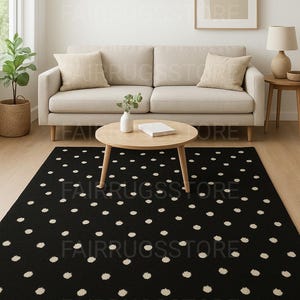 May include: A rectangular area rug featuring a solid black background with a repeating pattern of small, off-white circular dots distributed evenly across the surface. The rug has a low-pile texture and clean, straight edges on all four sides.