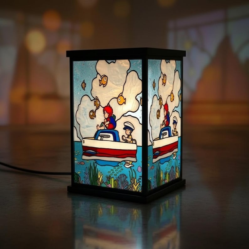 May include: A decorative lamp with a black frame featuring a nautical scene. The lamp's panels depict a boat with two people, fish, and underwater plants. The boat is red and white, set against a blue background.