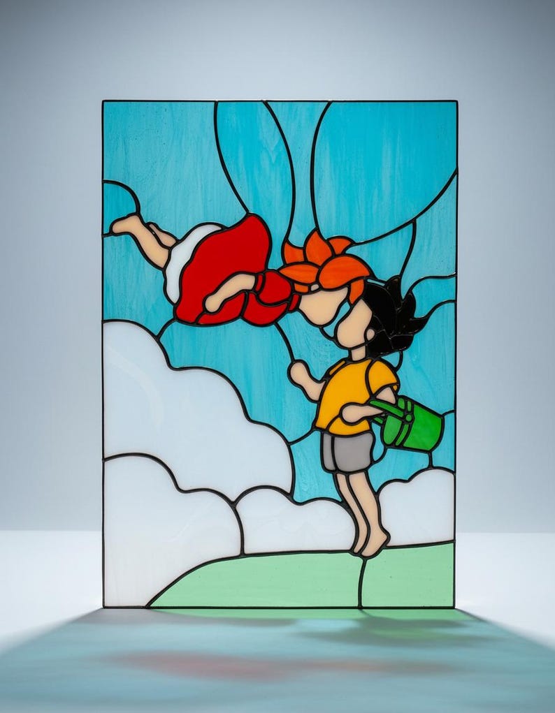 May include: Stained glass panel featuring a whimsical scene of two figures. One figure is in a red dress, the other in a yellow shirt, holding a green bucket. The background is a light blue sky with white clouds and green grass.