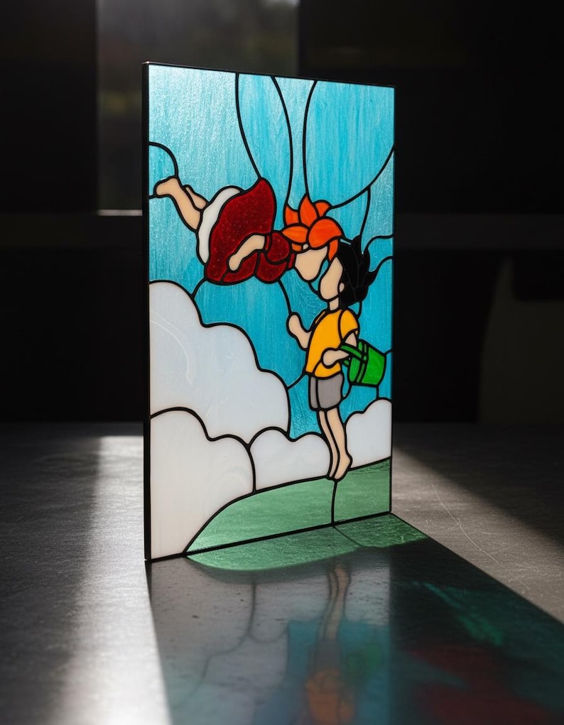 May include: Stained glass panel featuring a whimsical scene of two cartoon figures in a blue sky with white clouds. One figure is wearing a red dress, and the other is wearing a yellow shirt and holding a green bucket. The panel has a black border.