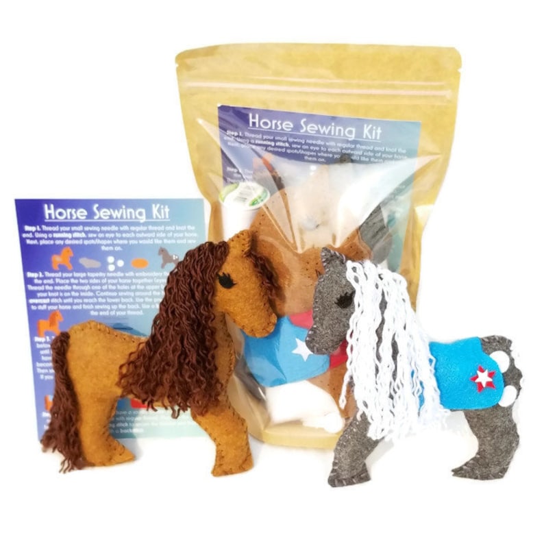 May include: Horse Sewing Kit with two felt horses, one brown with brown mane and tail, and one gray with white mane and tail. The kit includes felt pieces, thread, needles, and instructions.  "Horse Sewing Kit" is printed on the packaging.