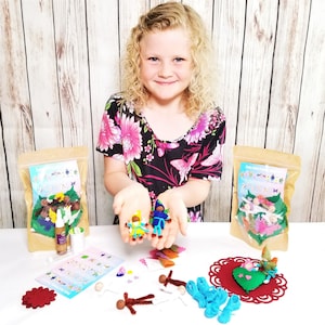 May include: A craft kit for making felt fairy dolls. The kit includes felt pieces, yarn, beads, and instructions. A young person is holding two completed fairy dolls.