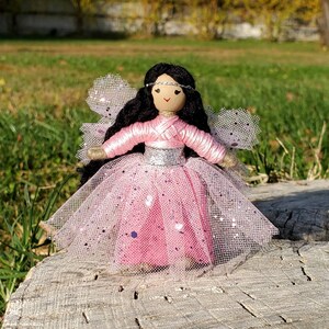 May include: A handmade fairy doll with long black hair, a pink tulle dress with silver glitter, and a silver headband with a white gem.