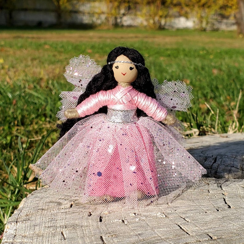 May include: A handmade fairy doll with long black hair, a pink tulle dress with silver glitter, and a silver headband with a white gem.