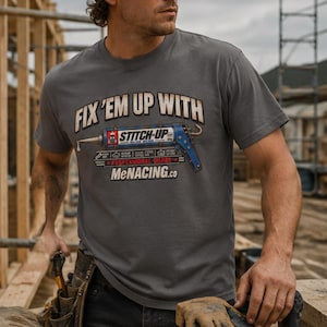May include: A charcoal gray short-sleeve t-shirt featuring a graphic of a blue caulking gun with the text "FIX 'EM UP WITH STITCH-UP" and "MeNACING.co" printed on the front. The design includes small icons and additional text details.
