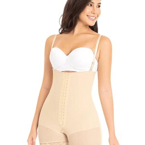 May include: Beige full-body shapewear with adjustable straps and a hook-and-eye closure down the front. The garment features a high waist, shorts-style legs with lace trim, and a sheer panel on the lower legs. The model is wearing a white bra.