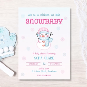 May include: A baby shower invitation with a watercolor snowman illustration. The invitation features the text "SNOWBABY" in pink, along with event details. A light blue mitten with snowflakes and a white tag are on the left.