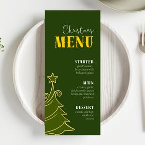 Może przedstawiać: Karta menu bożonarodzeniowego z ciemnozielonym tłem i złotym tekstem. Menu zawiera przystawki, dania główne i desery. Po lewej stronie znajduje się dekoracyjna grafika choinki. Widoczne są również sztućce i talerz.