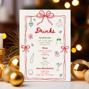 May include: A festive Christmas drinks menu with red and green illustrations and text. The menu includes cocktails, wine, beer, and non-alcoholic options. Gold Christmas ornaments and a candle are in the foreground.