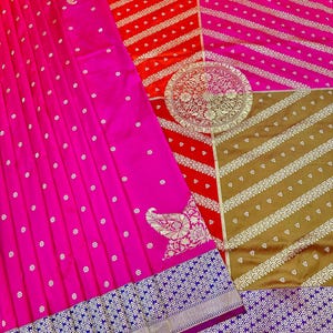 May include: A vibrant pink saree with intricate gold and silver detailing. The saree features a floral pattern and a decorative border with a geometric design. The design includes red, pink, and gold sections.