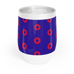May include: A stainless steel insulated tumbler. The body is blue with a pattern of red circles. The base is white, and the top is silver. The tumbler is designed to keep drinks at the desired temperature.