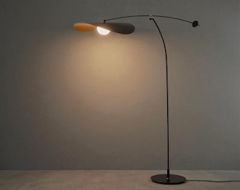 May include: A modern black floor lamp with a curved arm and a unique, petal-shaped lampshade. The lampshade is a combination of black and light brown, with a bright light emanating from the center. The lamp has a round base and a minimalist design.