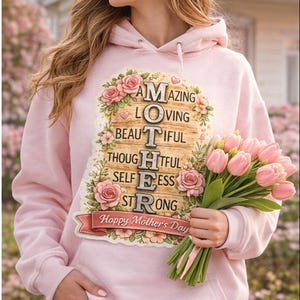May include: A pale pink hoodie featuring the words "AMAZING LOVING BEAUTIFUL THOUGHTFUL SELFLESS STRONG" surrounded by roses and leaves. The text "Happy Mother's Day" is below. A bouquet of pink tulips is held in the hand.