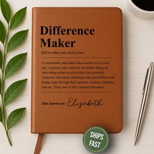May include: A brown leather journal with the words "Difference Maker" embossed on the cover. The definition of "Difference Maker" is printed below the title. The journal also includes the name "Elizabeth" and a "Ships Fast" sticker.