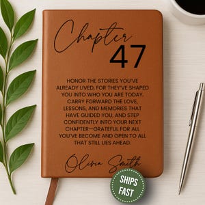 May include: A brown leather journal with the words "Chapter 47" in black script. The journal includes inspirational text and the name "Olivia Smith." A silver pen and a cup of coffee are next to the journal.