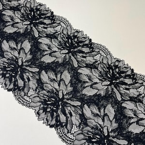 Könnte beinhalten: Schwarze florale Spitzenborte mit großen, detaillierten Blumenmustern. Die Spitze hat einen gewellten Rand und ist auf einem weißen Hintergrund angeordnet. Diese dekorative Borte eignet sich für verschiedene Bastel- und Nähprojekte.