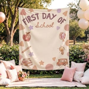Peut inclure: Une toile de fond en tissu crème avec le texte FIRST DAY OF School en marron. Le motif comprend des illustrations d'une pomme, d'un crayon, d'une pile de livres, d'un globe, d'une ampoule, d'un bus scolaire et diverses formes géométriques.