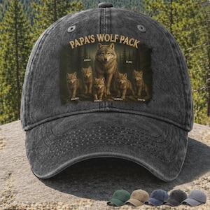 Puede incluir: Gorra de béisbol negra desgastada con el texto "PAPA'S WOLF PACK" y un diseño de familia de lobos. Los nombres "ANNA", "ELISE", "HARRY", "JAMES", "SOPHIA" y "DAVID" están impresos debajo. La gorra tiene una visera curva.