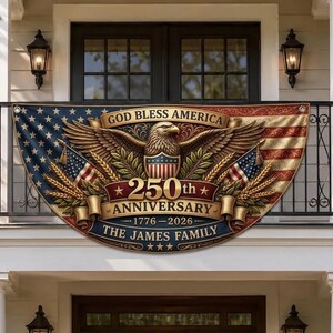 Op de afbeelding: Een patriottische banner met de tekst "GOD BLESS AMERICA" en "250th ANNIVERSARY 1776-2026 THE JAMES FAMILY". De banner toont een adelaar, Amerikaanse vlaggen en een sterren- en strepenontwerp, geschikt voor buitendisplay.