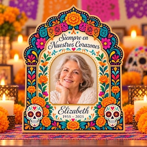 May include: A decorative wooden memorial frame featuring a colorful floral and sugar skull border. The text reads "Siempre en Nuestros Corazones" at the top and "Elizabeth 1955 - 2025" at the bottom, surrounding a central portrait of a woman.