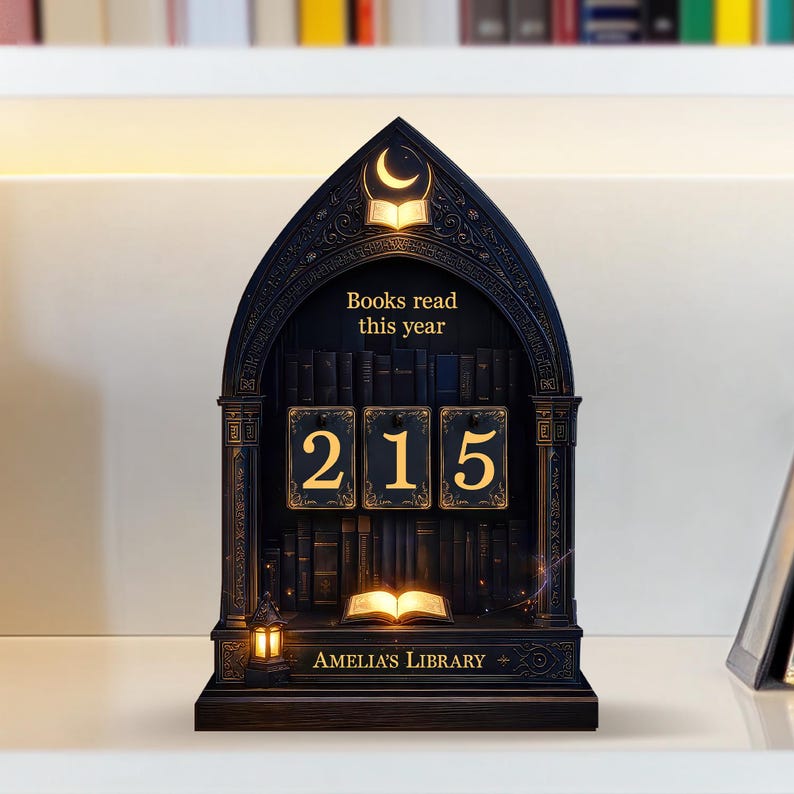 May include: A dark wooden bookshelf-shaped display with the text "Books read this year" and the number "215". The display has a crescent moon and open book design at the top, with the words "Amelia's Library" at the bottom.