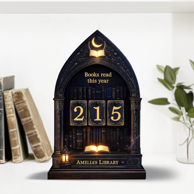 May include: A dark wooden bookshelf-shaped desk organizer with the text "Books read this year" and the numbers "215". The organizer has a crescent moon and open book design at the top, with the words "Amelia's Library" at the bottom.